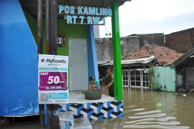 Warga Kampung Karang Kimpul, Kelurahan Kaligawe, Kecamatan Gayamsari, Kota Semarang, Melakukan Aktivitas Sehari-hari Mereka Di Rumah Yang Masih Tergenang Banjir, Jumat (15/03).