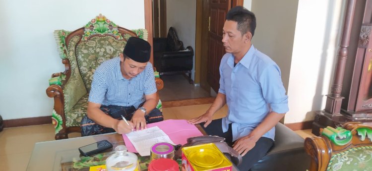 Kepala Desa Undaan Tengah Dedy Arisanto (berpeci) menandatangani berita acara dari petugas Polsek Undaan terkait kematian salah satu warganya. Arif Edy Purnomo/RMOLJateng